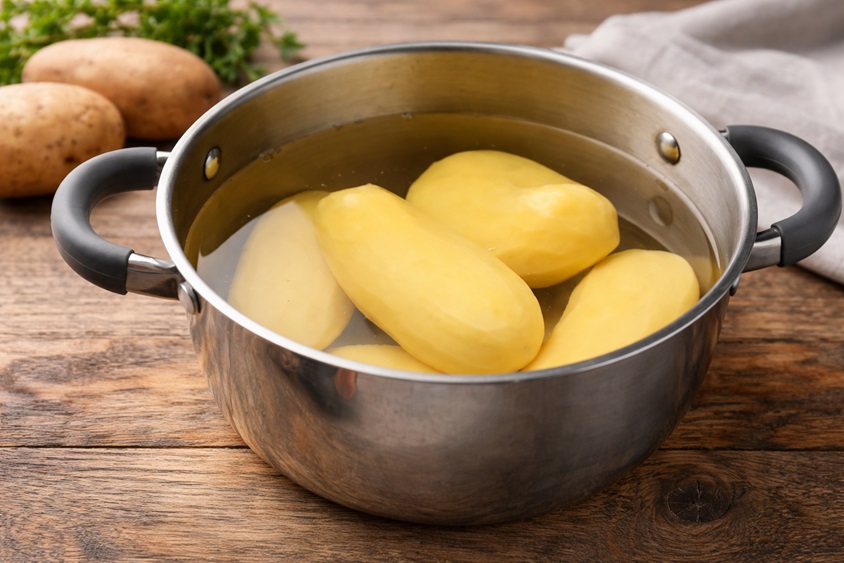Gekochte Kartoffeln, geschält mit Wasser im Kochtopf.