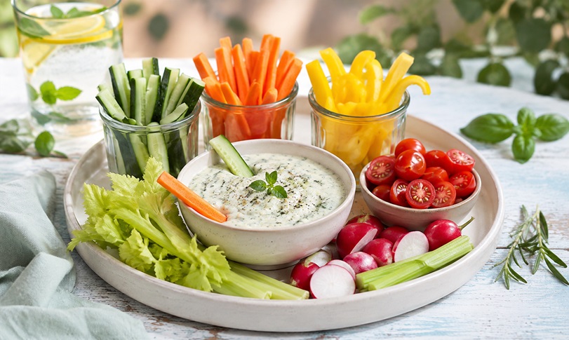 Leichte Snacks für heiße Sommertage - Gemüsesticks, Tomaten und Radieschen mit Kräuterdip.
