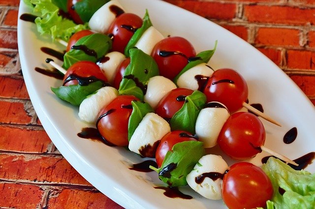Leiche Snacks - Tomaten-Mozzarella-Spieße auf einem Teller.
